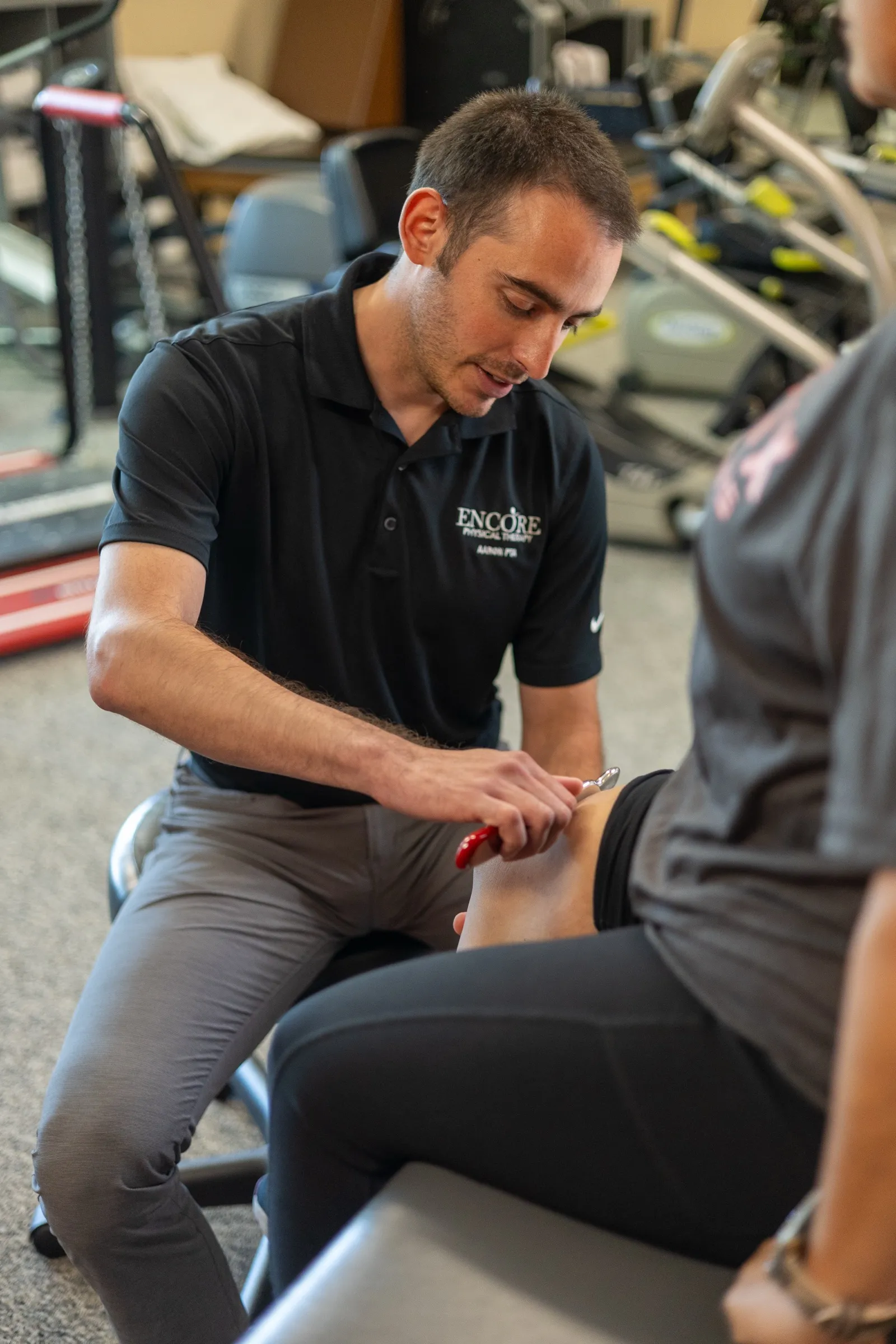 An Encore therapist performing soft-tissue treatment on a patient’s leg